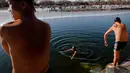 Sejumlah pria berenang di Danau Shichahai yang setengah beku di Beijing, (24/1). Menurut beberapa penduduk setempat, berenang di air dingin baik untuk kesehatan. (AP Photo / Andy Wong)