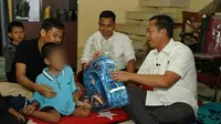 Direktur Reserse Kriminal Umum Polda Riau Kombes Asep Darmawan memberikan tas agar anak disabilitas korban penganiayaan bisa sekolah. (Liputan6.com/M Syukur)