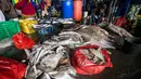 Nelayan saat memotong ikan hasil tangkapannya, termasuk hiu, di sebuah tempat pelelangan ikan di Brondong, Lamongan, Jawa Timur, Senin (13/3). (AFP Photo/Juni Kriswanto)