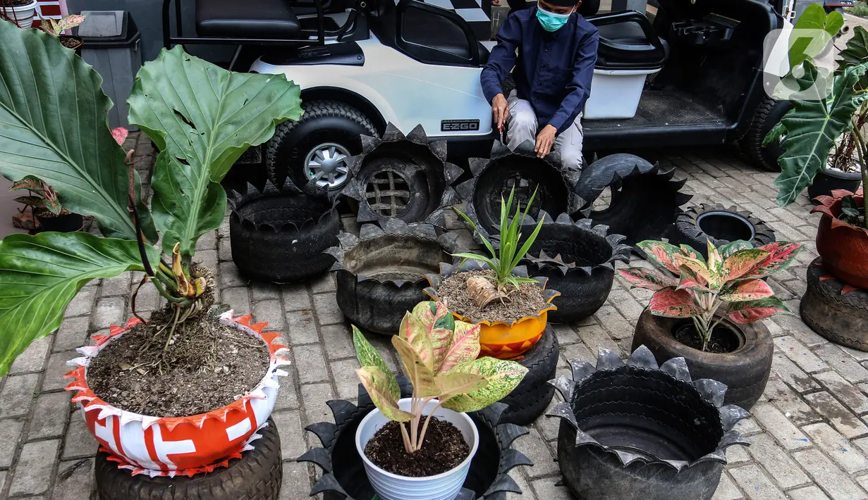 Abdul Kholik menyelesaikan pembuatan pot bunga dari ban bekas di Galeri Abdul Kholik, Tapos, Depok, Jumat (30/10/2020). Kerajinan pot bunga dari limbah ban bekas mobil Boogie Car atau mobil golf itu dijual seharga Rp75 ribu hingga Rp100 ribu tergantung warna dan ukuran. (Liputan6.com/Johan Tallo)