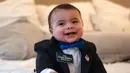 Wali Kota Kehormatan Whitehall Charlie McMillan tertawa di rumahnya di Whitehall, Texas, Amerika Serikat, Jumat (20/12/2019). Bayi berusia tujuh bulan tersebut diangkat menjadi Wali Kota Kehormatan Whitehall dan menjadikannya sebagai wali kota termuda di AS. (Mark Felix/AFP)