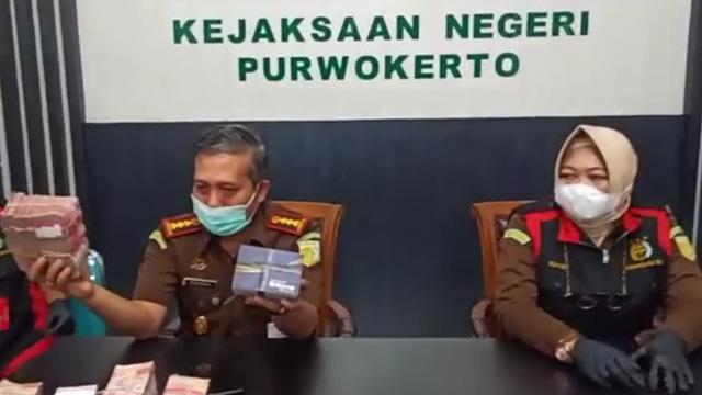 Kajari Purwokerto, Sunarwan, (kiri) menunjukkan barang bukti uang tunai Rp 470 juta yang disita dari rumah seorang saksi kasus dugaan korupsi dana JPS Kemenaker. (Foto: Liputan6.com/Kejari Purwokerto)