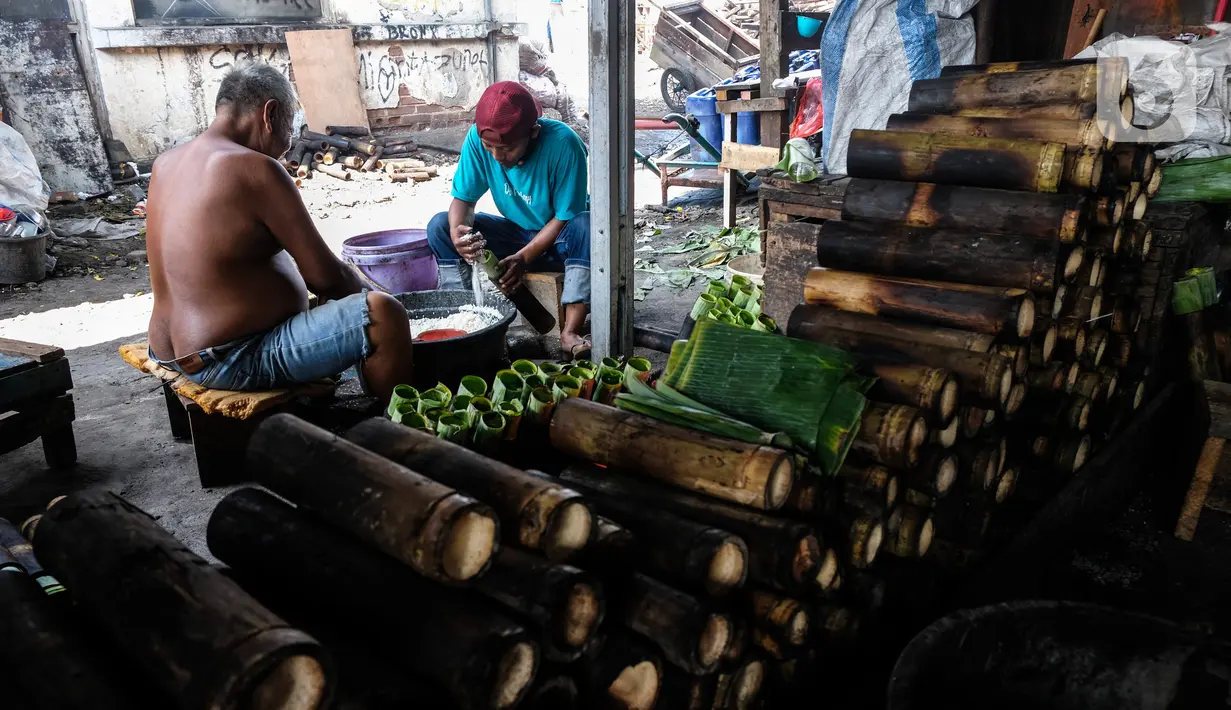 Pekerja memasukan beras ke dalam bambu yang dibungkus daun pisang di industri pembuatan lemang kawasan Senen, Jakarta, Selasa (27/4/2021). Tempat pembuatan nasi lemang yang sudah berdiri sejak 1970 ini selama bulan ramadhan membuat 300 batang nasi lemang per hari. (Liputan6.com/Johan Tallo)