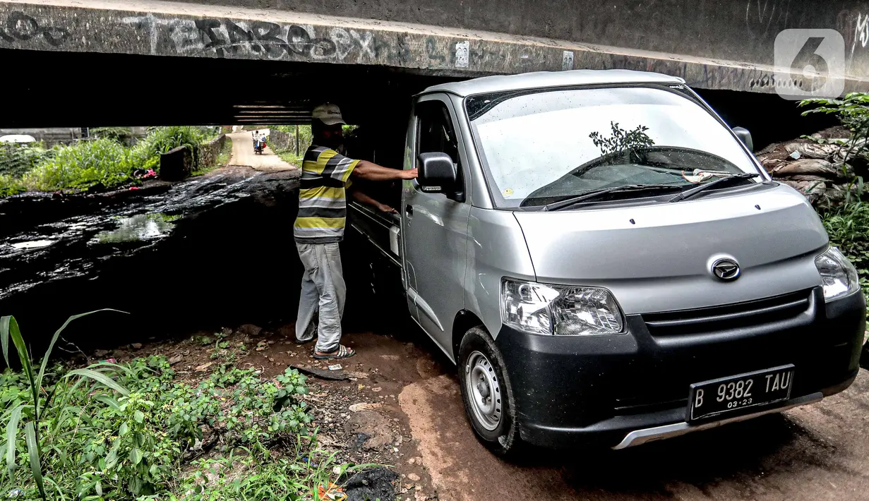 Pengendara mobil melintas di kolong Tol Jagorawi, Cimanggis, Depok, Jawa Barat, Minggu (8/11/2020). Buruknya jalan dan minimnya penerangan membuat akses tersebut rawan aksi kejahatan. (Liputan6.com/Faizal Fanani)