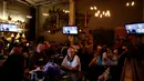 Pendukung Partai Demokrat terlihat serius menyaksikan debat Capres AS Donald Trump dan Hillary Clinton di Sebuah Restoran di Meksiko, (19/10). Debat kali ini menjadi pertarungan terakhir keduanya jelang Pemilu di AS. (Reuters/Carlos Jasso) 