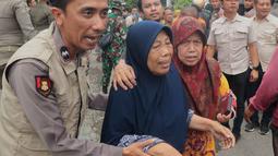 Sebanyak 102 santri korban ambruknya bangunan musala di Pondok Pesantren (Ponpes) Al Khoziny di Sidoarjo, Jawa Timur berhasil dievakuasi. Tampak dalam foto, petugas polisi membantu seorang perempuan berjalan keluar setelah bangunan runtuh di sebuah pesantren di Sidoarjo, Jawa Timur, Selasa 30 September 2025. (AP Photo/Trisnadi)