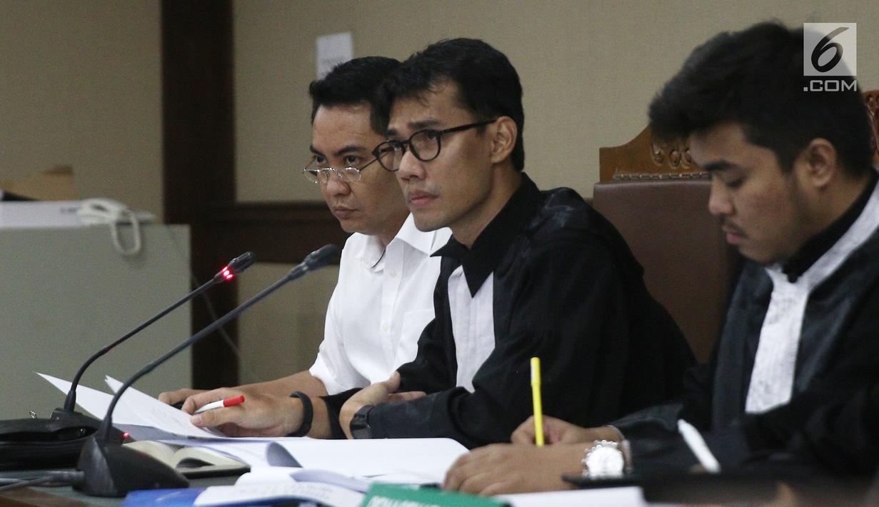 Ekspresi terdakwa dugaan suap pengadaan satelit monitoring Bakamla, Fayakhun Andriadi (kiri) saat sidang lanjutan di Pengadilan Tipikor, Jakarta, Rabu (10/10). Sidang mendengarkan keterangan saksi ahli kuasa hukum terdakwa. (Liputan6.com/Herman Zakharia)