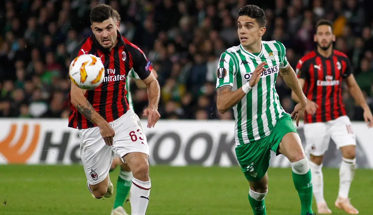 Striker AC Milan, Patrick Cutrone berusaha mengejar bola dari kawalan bek Real Betis, Marc Batra selama pertandingan grup F Liga Europa di stadion Benito Villamarin, Sevilla (8/11). Milan menahan imbang Betis 1-1. (AP Photo/Manuel Gomez)