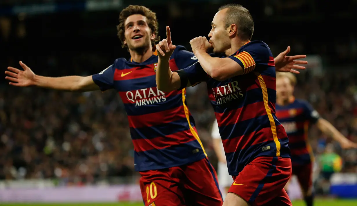 Gelandang Barcelona Andres Iniesta (kanan) melakukan selebrasi setelah mencetak gol ketiga di stadion Santiago Bernabeu, Spanyol, (22/11). ). Barcelona mengalahkan Real Madrid dengan skor 4-0. (Reuters/Sergio Perez)
