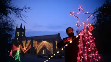 Seorang pria memasang dekorasi lampu di luar sebuah gereja di Peshawar, Pakistan barat laut (14/12/2020). Menyambut Natal, warga Pakistan mendekorasi rumah atau tempat ibadah agar lebih indah. (Xinhua/Umar Qayyum)