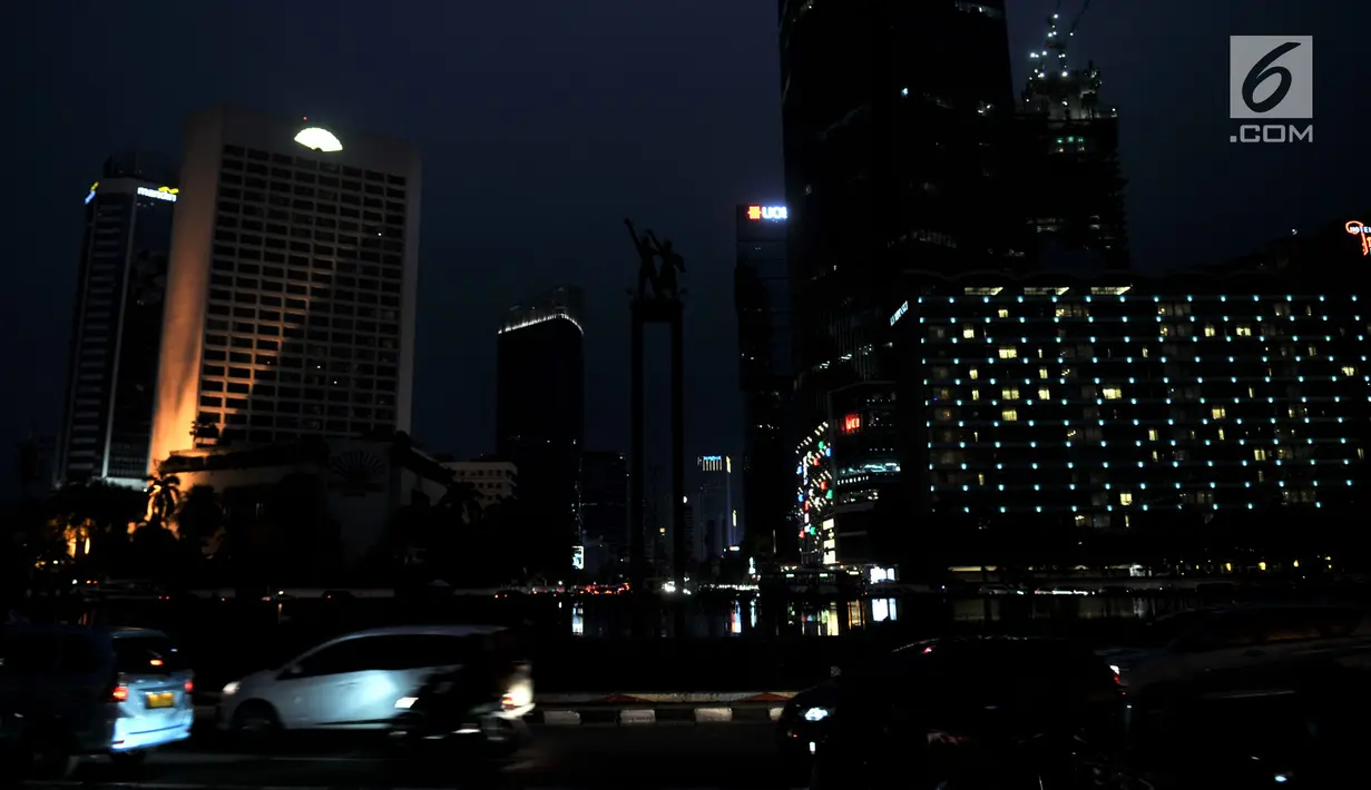 Sejumlah kendaraan melintas dengan kondisi jalan gelap tanpa penerangan akibat listrik padam di kawasan Bundaran HI, Jakarta, Minggu (4/8/2019). Pemadaman listrik serentak yang terjadi sejak Minggu siang mengubah suasana malam di ibu kota menjadi gelap gulita. (merdeka.com/Iqbal S. Nugroho)