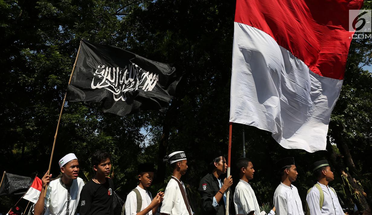 Massa Aksi Bela Tauhid mengibarkan bendera Merah Putih dan bendera bertuliskan kalimat tauhid di depan Gedung Kemenko Plhukam, Jakarta, Jumat (26/10). Aksi diikuti ribuan orang dari berbagai organisasi Islam. (Merdeka.com/Imam Buhori)