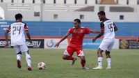 Pergerakan bek Persis, Wirabuana Prayogo (merah), saat dikepung dua pemain Madura FC dalam laga di Stadion Wilis, Madiun, Rabu (18/9/2019). (Bola.com/Vincentius Atmaj