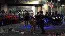 Seorang polisi anti huru hara menghadapi seorang suporter Argentina selama bentrokan setelah perayaan timnas Argentina meraih juara Piala Dunia Qatar 2022 di lingkungan Obelisk di Buenos Aires (20/12/2022). (AFP/Luis Robayo)
