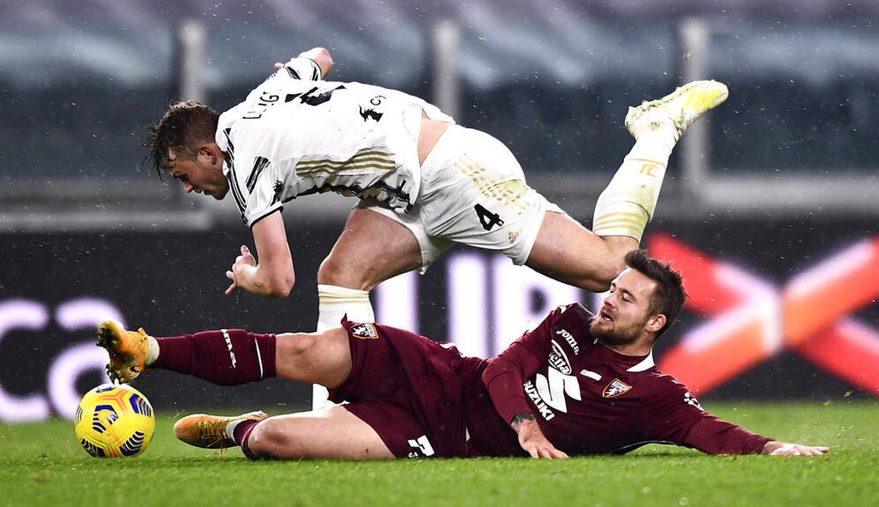 Bek Juventus, Matthijs de Ligt, terjatuh saat berebut bola dengan pemain Torino, Karlol Linetty, pada laga Liga Italia di Stadion Allianz, Minggu (6/12/2020). Juventus menang dengan skor 2-1. (Fabio Ferrari/LaPresse via AP)