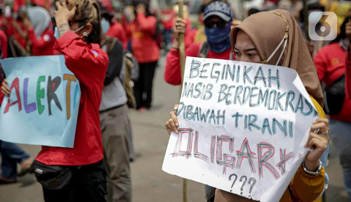 Massa buruh membawa poster saat menggelar unjuk rasa di depan Kompleks Gedung DPR/MPR, Jakarta, Selasa (17/11/2020). Buruh kembali menggelar aksi lanjutan menuntut pemerintah dan DPR untuk mencabut Omnibus Law Undang-Undang Cipta Kerja. (Liputan6.com/Faizal Fanani)