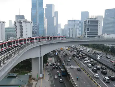 Kereta Lintas Raya Terpadu atau Light Rail Transit (LRT) melintas di jembatan lengkung (longspan) LRT Kuningan, Jakarta, Kamis (3/8/2023). Wakil Menteri BUMN Kartika Wirjoatmodjo menyebutkan konstruksi jembatan lengkung dari Gatot Subroto menuju ke Kuningan salah desain sehingga menyebabkan rangkaian kereta LRT yang melintas harus berjalan melambat. (Liputan6.com/Herman Zakharia)