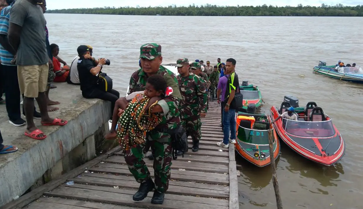 Satgas Kesehatan TNI memberi bantuan pengobatan wabah penyakit di Kabupaten Asmat, Papua, Jumat (19/1). Tim terdiri atas Pusat Kesehatan TNI dan TNI AD, Dinas Kesehatan TNI AL dan TNI AU bersama dinas kesehatan setempat. (LIputan6.com/Pool/Puspen TNI)