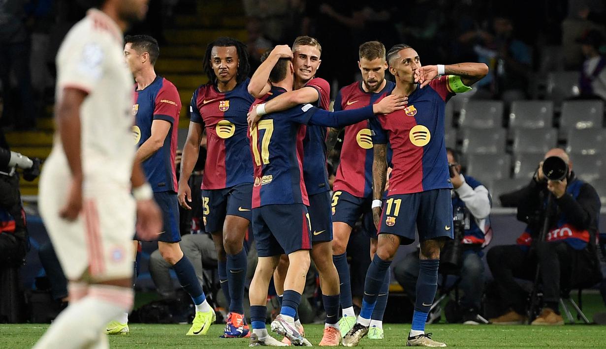 Penyerang Barcelona, Raphinha (kanan) merayakan gol pada laga lanjutan Liga Champions 2024-2025 melawan FC Bayern Munchen di Estadi Olimpic Lluis Companys, Barcelona, Rabu 23 Oktober 2024 atau Kamis 24 Oktober 2024 dini hari WIB. (Josep LAGO/AFP)