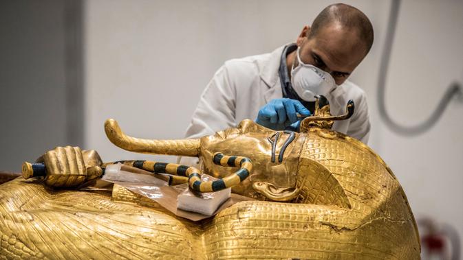 Mesir Segera Restorasi Peti Firaun: Arkeolog merestorasi peti mati emas Firaun Tutankhamun di laboratorium restorasi Grand Egyptian Museum (GEM), Giza, Mesir, Senin (13/4/2020). Firaun Tutankhamun merupakan Raja Mesir Kuno yang memerintah antara tahun 1342-1325 SM. (Khaled DESOUKI AFP)