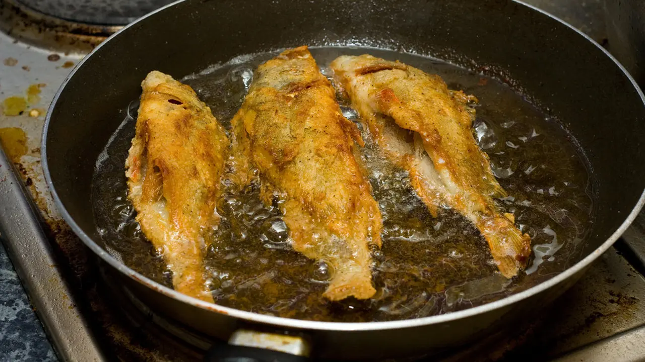 Ilustrasi menggoreng ikan.