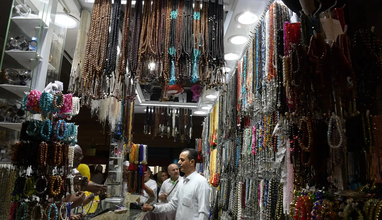 Jemaah haji memilih tasbih di sebuah toko di kota suci Makkah, Arab Saudi pada Selasa (6/8/2019). Puncak Ibadah haji masih beberapa hari lagi, namun jemaah sudah memborong aneka barang antara lain tasbih, baju, teko emas, kurma, sajadah, minyak wangi, pacar kuku, dan lainnya. (FETHI BELAID/AFP)