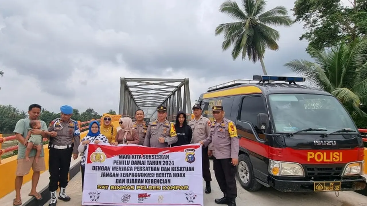 Personel Polres Kampar bersama masyarakat dalam sosialisasi Pemilu damai.