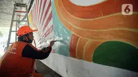 Petugas PPSU melukis mural dengan warna-warna cerah sehingga kolong Semanggi terlihat lebih cerah. Liputan6.com/Faizal Fanani)