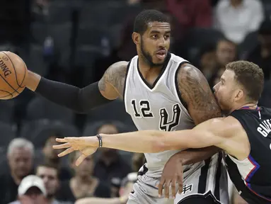 Pemain San Antonio Spurs, LaMarcus Aldridge #12 mencoba melewati hadangan pemain Los Angeles Clippers, Blake Griffin #32 pada laga NBA basketball game, (5/11/2016) di AT&T Center, San Antonio. (AP/Eric Gay)