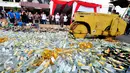 Petugas mengoperasikan Alat Berat untuk menghancurkan botol minuman keras (miras) di Mapolres Jakarta Selatan, Rabu (10/6/2015). Pemusnahan 8.000 botol miras untuk menekan peredaran miras khususnya menjelang bulan Ramadan. (Liputan6.com/Yoppy Renato)