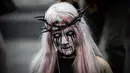 Penggemar film horor memakai kostum dan berdandan menyerupai zombie saat berpartisipasi dalam acara Zombie Walk di Place de la Republique, Paris, Sabtu (12/10/2019). Sejak 2008, acara Zombie Walk digelar untuk orang-orang yang terobsesi dengan mayat hidup. (Martin BUREAU / AFP)