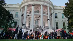 Gedung Putih membuka halaman selatannya untuk hantu-hantu dalam acara halloween yang digelar Presiden AS, Donald Trump, Senin (30/10). Agak semarak, Gedung Putih didekorasi dengan sarang laba-laba, kelelawar dan labu oranye. (AP/Pablo Martinez Monsivais)