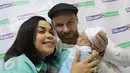 Melaney Ricardo bersama Tyson Lynch menggendong bayi laki-lakinya usai konferensi pers di RS Siloam Kebon Jeruk, Jakarta, Kamis (5/5). Melaney akan kembali beraktivitas dalam waktu normal ibu melahirkan, yakni 40 hari lagi. (Liputan6.com/Herman Zakharia)