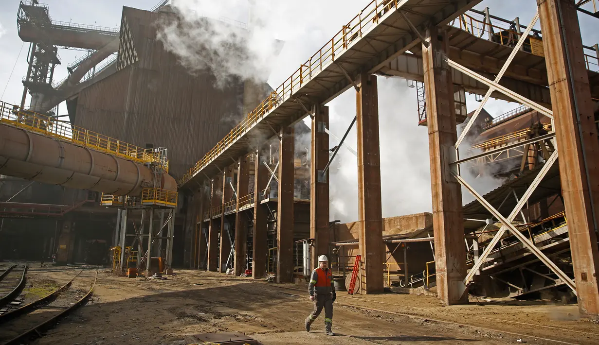 Seorang pekerja berjalan di depan pabrik baja ArcelorMittal di Zenica, Bosnia dan Herzegovina, (9/2). ArcelorMittal merupakan produsen baja terbesar di dunia yang tersebar di sekitar 60 negara dan berpusat di Luksemburg. (REUTERS/Dado Ruvic)