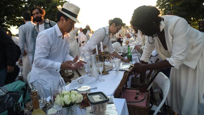 Para peserta dalam balutan serba putih  berkumpul untuk Dinner en Blanc atau 