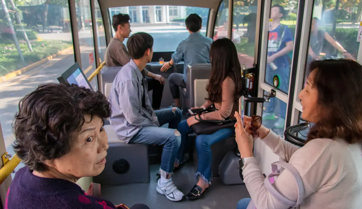 Sejumlah penumpang menaiki minibus tanpa awak di Shanghai Jiao Tong University di Shanghai, China (8/5). Beberapa fitur terbaru seperti hemat energi, dan manufaktur dengan kualitas terbaik, melekat pada bus. (AFP Photo/China Out)