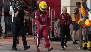 Pembalap Ferrari asal Inggris, Lewis Hamilton (tengah), berjalan di jalur pit selama sesi kualifikasi sprint menjelang Grand Prix Formula Satu Qatar di Sirkuit Internasional Lusail pada 28 November 2025. (Altaf Qadri/ POOL/AFP)