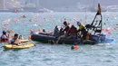 Petugas menyelamatkan perenang yang kelelahan ketika lomba renang lintas pelabuhan berjarak 1.500 meter di Hong Kong, Minggu (16/10). Sejumlah peserta lomba renang tahunan Lintas Pelabuhan Hong Kong mengalami kelelahan dan tenggelam. (REUTERS/APPLE DAILY)