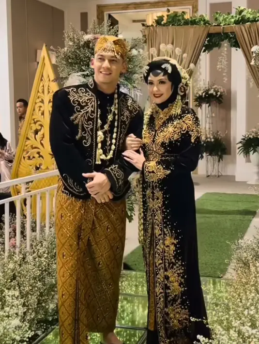 Revalina dan Samuel mengenakan baju adat Jawa warna hitam bahan velvet dengan aksen bordiran emas. Samuel mengenakan beskap lengkap dengan ronce melati dan blangkonnya.[@vatemat]