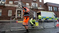 Pekerja memasang pagar pembatas di seberang area Lingdo Wing, Rumah Sakit St. Mary di Paddington, London, Senin (9/4). Rumah sakit tempat Kate Middleton direncanakan akan melahirkan mulai meningkatkan aktivitas pengamanannya. (AP/Kirsty Wigglesworth)