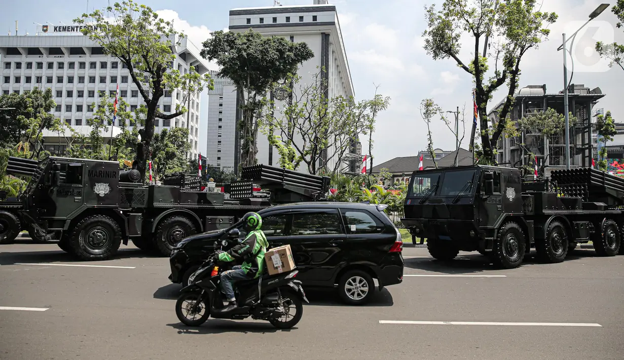 Pengendara melintas saat sejumlah kendaraan alat utama sistem senjata (alutsista) TNI berjajar di kawasan Istana Merdeka, Jakarta, Selasa (4/10/2022). Kegiatan ini dalam rangka HUT ke-77 TNI yang akan berlangsung di Istana Merdeka pada 5 Oktober besok. (Liputan6.com/Faizal Fanani)