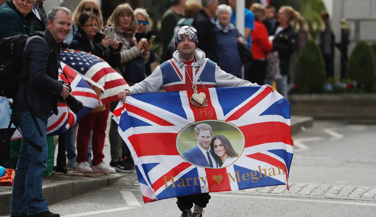 Warga mengibarkan bendera Inggris disertai gambar Pangeran Harry dan Meghan Markle setelah usai keduanya melahirkan anak pertama mereka di London, Inggris, Senin (6/5/2019). Warga pun bersuka cita atas kedatang anak berjenis kelamin laki-laki tersebut. (Dominic Lipinski/PA via AP)
