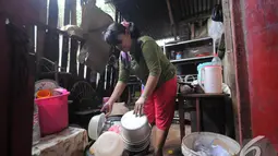 Sawiah, ibunda Sony Wakwaw membereskan barang saat akan pindah ke rumah yang baru. Sawiah bekerja sebagai buruh cuci. Foto diambil pada Kamis (4/12/2014). (Liputan6.com/Herman Zakharia)