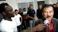 Bintang Persib Bandung, Michael Essien bertingkah seperti jurnalis saat berpura-pura mewawancarai manajer tim, Umuh Muchtar. (Bola.com/Erwin Snaz)
