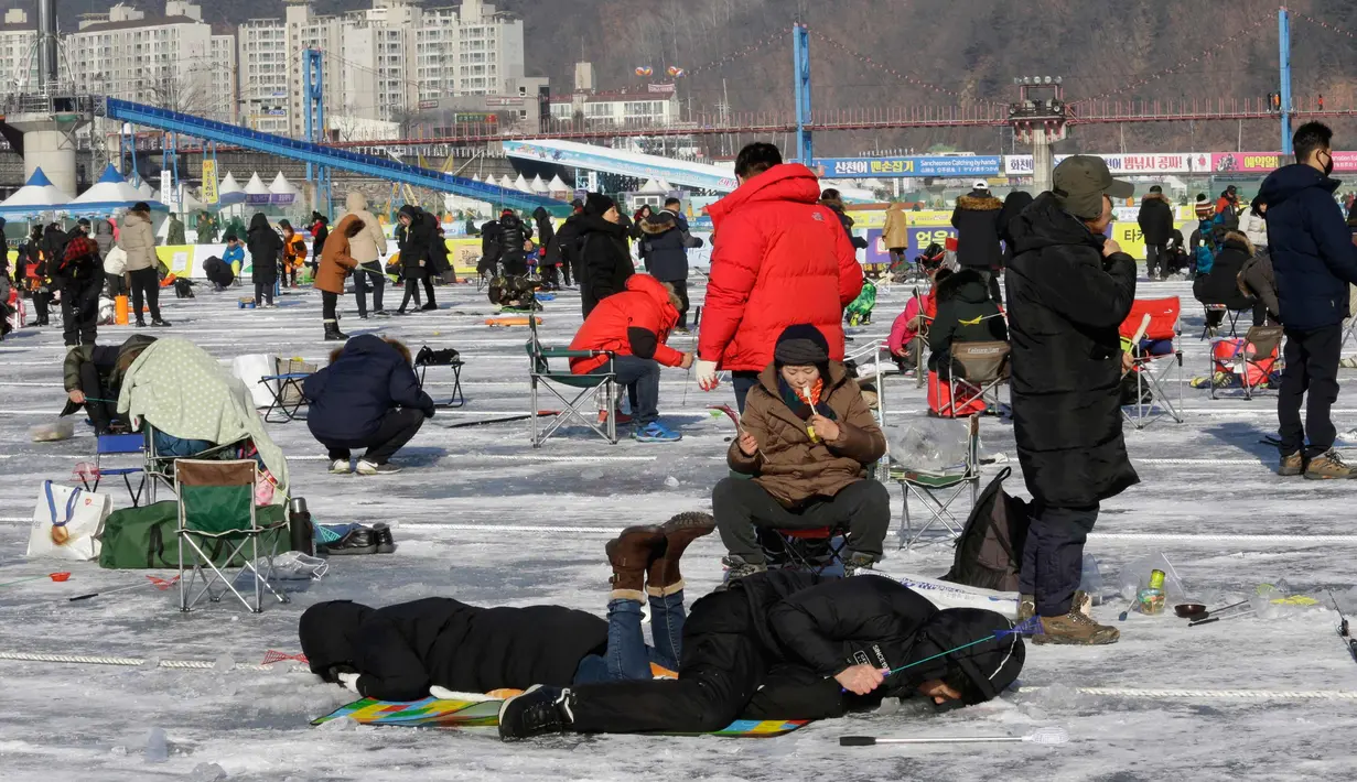 Peserta saat mengikuti lomba memancing ikan trout di sungai yang membeku di Hwacheon, Korea Selatan (6/1). Kontes ini merupakan bagian dari festival es tahunan yang menghasilkan lebih dari 1.000.000 pengunjung setiap tahunnya. (AP Photo/Ahn Young-joon)