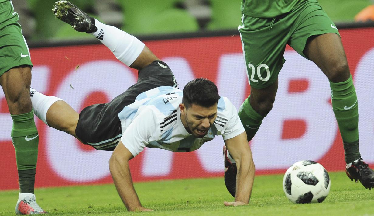 Striker Argentina, Sergio Aguero, terjatuh saat berebut bola dengan pemain Nigeria pada laga persahabatan di Stadion FK Krasnodar, Rabu (15/11/2017). Argentina kalah 2-4 dari Nigeria. (AP/Sergey Pivovarov)