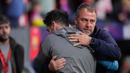Pelatih Barcelona, Hansi Flick, memeluk pelatih Atletico Madrid, Diego Simeone, dalam laga leg kedua semifinal Copa del Rey 2024/2025 di Metropolitano, Kamis (03/04/2025) dini hari WIB. (AP Photo/Manu Fernandez)