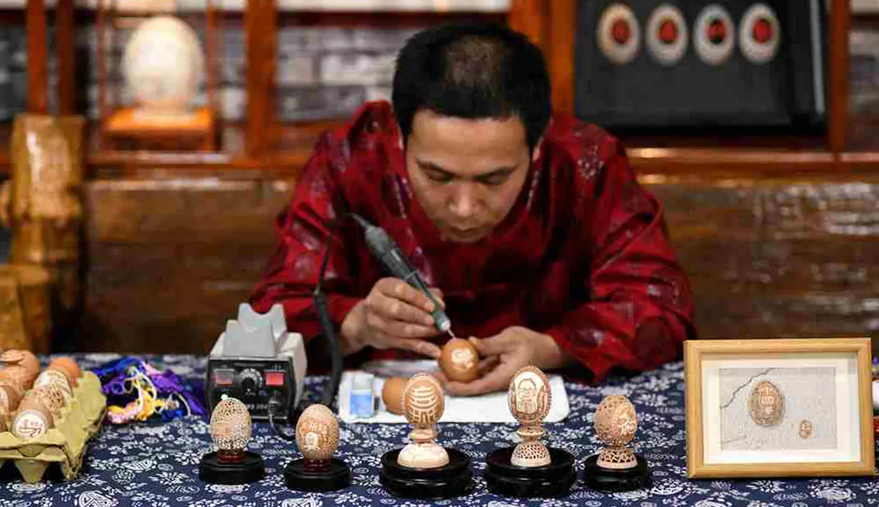 Zhang Xiaohe membuat kerajinan ukiran telur di sebuah lokakarya warisan budaya takbenda di Shijiangzhuang, China pada 17 April 2020. Ukiran telur sering disebut "seni yang paling rapuh", karena membutuhkan ketelitian dan perhatian tinggi sebelum, selama dan setelah pembuatannya. (Xinhua/Chen Qibao)