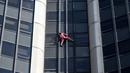 Alain Robert, pendaki bangunan pencakar langit asal Prancis memanjat Menara Montparnasse di Paris, Prancis, Rabu (12/10/2022). Alain Robert yang dikenal sebagai Spiderman Prancis itu kembali beraksi dengan memanjat Menara Montparnasse yang memiliki ketinggian 210 meter. (Bertrand GUAY/AFP)