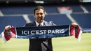 Kiper anyar PSG, Gianluigi Buffon berpose dengan syal klub barunya saat sesi perkenalan di stadion Parc des Princes, Paris, Senin (9/7). Paris Saint-Germain ( PSG) secara resmi memperkenalkan Gianluigi Buffon sebagai pemain baru. (AP/Jean-Francois Badias)